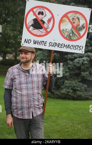 Protestante ha un segno di confronto tra il presidente americano Donald Trump e Hitler durante un raduno contro la supremazia bianca e l'islamofobia al Queen's Park di Toronto, Ontario, Canada, il 15 ottobre 2017. (Foto di Creative Touch Imaging Ltd./NurPhoto) Foto Stock