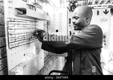 Un colpo in scala di grigi di uomo africano al Centro di formazione professionale in Africa Foto Stock