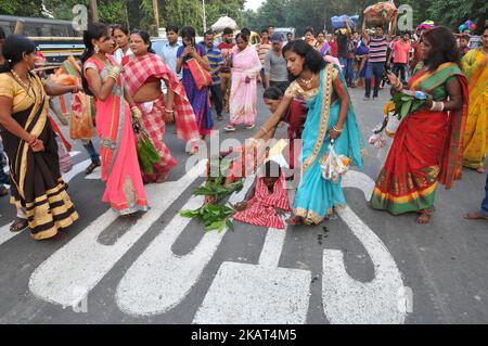 Una donna indiana che giace prostrata adorando il dio Sole durante Chhat puja su una strada a Kolkata prima di andare al fiume Hooghly. Chhath è un antico festival indù e solo Vedic Festival dedicato al Dio del Sole indù, Surya e Chhathi Maiya il 26,2017 ottobre a Kolkata, India. (Foto di Debajyoti Chakraborty/NurPhoto) Foto Stock
