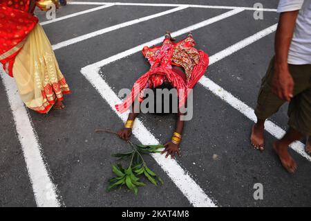 Una donna indiana che giace prostrata adorando il dio Sole durante Chhat puja su una strada a Kolkata prima di andare al fiume Hooghly. Chhath è un antico festival indù e solo Vedic Festival dedicato al Dio del Sole indù, Surya e Chhathi Maiya il 26,2017 ottobre a Kolkata, India. (Foto di Debajyoti Chakraborty/NurPhoto) Foto Stock