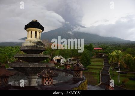 Vista generale del Monte Agung durante un'eruzione vista dal sub-distretto di Kubu nella reggenza di Karangasem, sull'isola turistica indonesiana di Bali, il 25 novembre 2017. Il Monte Agung, Bali, Indonesia, eruttò per la seconda volta in modo freatico rilasciando fumo grigio e cenere a 3 km di altezza dalla cima del cratere, il 25th 2017 novembre. Tuttavia, non tutte le persone che vivono nella zona pericolosa non vogliono evacuare. Questo perché, dopo due mesi che si dice eruttino, non è successo nulla. (Foto di Keyza Widiatmika/NurPhoto) Foto Stock