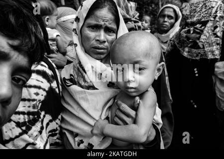 La donna rifugiata Rohingya tiene il suo bambino in attesa di assistenza medica in una clinica sul campo da parte dell'organizzazione non governativa Mercy Malaysia al campo profughi di Thankhali vicino a Cox's Bazar, Bangladesh, 24 novembre 2017. (Foto di Szymon Barylski/NurPhoto) Foto Stock