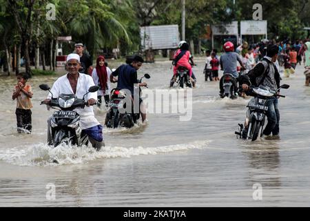 Le persone passano attraverso le inondazioni causate da forti precipitazioni nel nord di Aceh il 2 dicembre 2017 nella provincia di Aceh, Indonesia. Secondo il rapporto Meteorologia climatologia e Geofisica (BMKG), il potenziale per pioggia pesante accompagnata da fulmini, venti alti e onde alte causate dalla tempesta di Dahlia nel Bengkulu sud-occidentale causando inondazioni, frane, pozzanghere, venti forti e alberi caduti, Giava e Sumatra. (Foto di Fachrul Reza/NurPhoto) Foto Stock