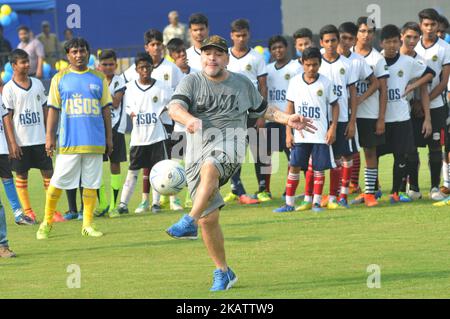 La leggenda del calcio argentina Diego Maradona calcia un calcio, gesti durante un workshop di calcio con gli studenti della scuola a Barasat, a circa 38 km a nord di Kolkata il 12 dicembre 2017. Maradona è in visita privata in India.Diego Armando Maradona è nato il 30 ottobre 1960.durante il suo periodo con la nazionale argentina, Maradona ha segnato 34 gol in 91 apparizioni. Debuttò a 16 anni a livello internazionale contro l'Ungheria il 27 febbraio 1977. Maradona è stata lasciata fuori dalla squadra argentina per la Coppa del mondo 1978 sul terreno di casa dal coach Cesar Luis Menotti che si sentiva troppo giovane all'età di 17.Maradon Foto Stock