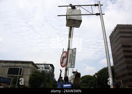 I funzionari del dipartimento trasporti di Giacarta smantellano i cartelli stradali che vietano il passaggio di veicoli a due ruote (motociclette) su Jalan MH. Thamrin, Central Jakarta, mercoledì 10 gennaio 2018. La demolizione dei segnali stradali, a seguito di una sentenza della Corte Suprema che ha concesso la petizione per il controllo giudiziario di due cittadini, Yuliansah e Diki, che si sono sentiti danneggiati dal motociclo divieto di regolamento per attraversare il protocollo strada MH. Thamrin e Medan Merdeka Barat, annullando il regolamento. A titolo informativo, le regole di divieto adottate per i motociclisti sono state adottate durante l'amministrazione di Giacarta, B. Foto Stock