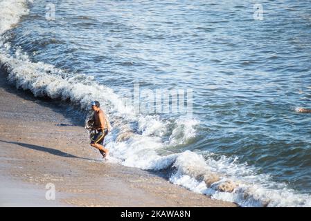 Salvador, Bahia, Brasile - 01 novembre 2021: Pescatore che lascia il mare con la rete di pesca alla spiaggia di Rio Vermelho a Salvador, Bahia. Foto Stock