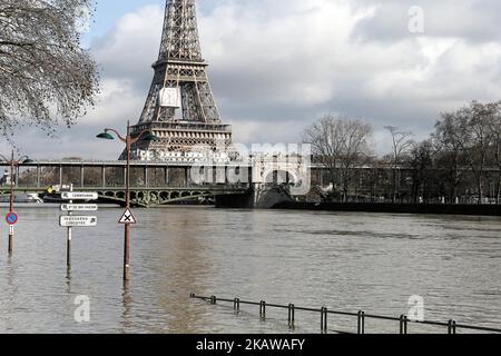 Una riva allagata della Senna di fronte alla Torre Eiffel il 26 gennaio 2018, come la Senna, Che attraversa Parigi, capitale francese, dovrebbe raggiungere un picco fino a 6,2 metri (20,3 piedi) su una scala utilizzata per misurare i suoi livelli entro gennaio 27, rendendola da quattro a cinque metri al di sopra della sua altezza normale. La Senna ha continuato il suo aumento incessante banchine alluvionali con acqua fangosa e mettendo i musei su un piano di emergenza come le precipitazioni record hanno spinto i fiumi sulle loro rive in tutta la Francia nord-orientale. (Foto di Michel Stoupak/NurPhoto) Foto Stock