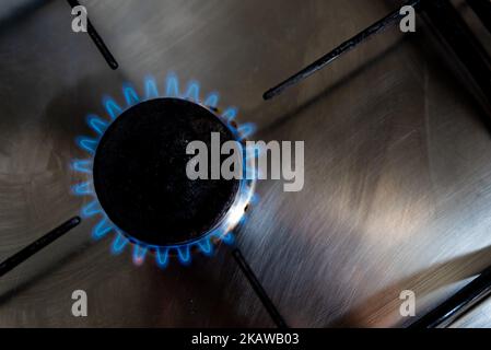 Una fiamma di gas blu è vista dalla parte superiore che proviene da un bruciatore domestico di gas di una stufa della cucina la parte superiore dovuto all'invasione russa dei prezzi del gas di Ucraina hav Foto Stock