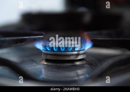 In questo primo piano una fiamma a gas blu da un bruciatore a gas è vista in una cucina. A causa dell'invasione russa dei prezzi del gas in Ucraina hanno raggiunto i massimi record in Foto Stock