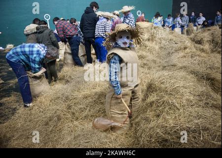 Un ragazzo attende con il suo costume 'Zako-Zahar' all'interno del frontone di Lesaka (Navarra) mentre il resto dei partecipanti a questo carnevale rurale si preparano a Lesaka, Navarra, Spagna, il 11 febbraio 2018. I 'zako-zahar' sono caratteri tipici del carnevale rurale di Lesaka (Navarra), farciti in sacchi pieni di paglia con le loro facce coperte da fazzoletti bianchi, che portano i neri gonfiati per battere le persone che camminano per le strade del villaggio al crepuscolo. Quando si stancano, si siedono sul pavimento uno in cima all'altro per riposare e divertirsi.ciò è uno dei carnevali ancestrali di cui l'origine è Foto Stock