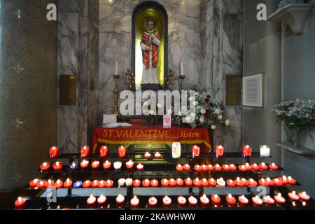 Una vista della cappella con la statua del santo patrono dell'amore, San Valentino, all'interno della chiesa di Whitefriar a Dublino. San Valentino, patrono dell'amore, fu giustiziato e sepolto a Roma il 14 febbraio 269. Più tardi, nel 1835, un sacerdote carmelitano irlandese, P. John Spratt, ha usato il suo fascino irlandese per convincere Papa Gregorio XVI ad esumare i resti di San Valentino e a portarlo in Irlanda come dono ai suoi compagni Irishmen e alle sue donne. Da allora, lo scheletro di San Valentino si trova sotto la chiesa di Whitefriar a Dublino. Nel 1950, una statua e un santuario sono stati costruiti per onorare San Valentino e collocati nella chiesa. Girata in cerca di amore Foto Stock