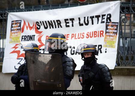 I poliziotti rioti sono in guardia di fronte a un banner che recita "Unisciti e combatti per fermarti a soffrire" vicino all'Università Fedreral di Tolosa. Più di 800 studenti, studenti delle scuole superiori, insegnanti hanno manifestato contro la selezione nelle università prevista dal gouvernment di Macron a Tolosa, in Francia, il 15st 2018 febbraio. Hanno protestato anche contro la fusione di università in cambio di denaro. Lo sciopero è stato chiamato da tutti i maggiori sindacati e sindacati studenti. Manifestazioni simili sono state organizzate altrove. (Foto di Alain Pitton/NurPhoto) Foto Stock