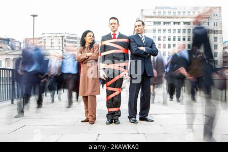 London Professionals, Red Tape. Linguaggio del corpo incomprensivo per un collega cittadino limitato dalla burocrazia. Da una serie di immagini correlate. Foto Stock