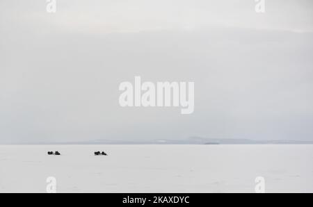 Gruppo di turisti in motoslitta su ghiaccio poco prima dell'inizio della Blizzard Foto Stock