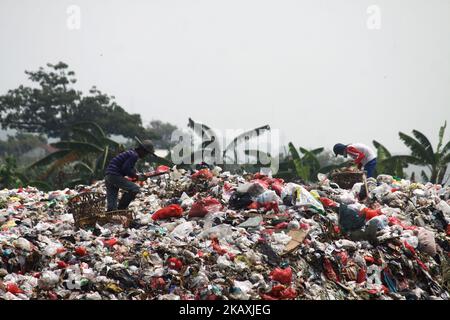 I sequestratori risolvono i rifiuti di plastica riciclabili a discariche illegali sulle rive del fiume CBL, distretto di Bekasi, Bekasi, Giava Occidentale sabato 14 aprile 2018. Con una popolazione di 2,4 milioni di persone, Bekasi come città satellite per Giacarta, si trova ad affrontare gravi problemi legati al trattamento dei rifiuti, che ha raggiunto le 1.700 tonnellate al giorno. In base ai dati dell'Agenzia per l'ambiente di Kota Bekasi, solo 600 tonnellate di rifiuti possono essere trasportate in discarica, mentre le restanti 1.100 tonnellate vengono smaltite in discariche illegali, come nei pressi di insediamenti o lungo il fiume. (Foto di Aditya Irawan/NurPhoto) Foto Stock