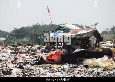 I sequestratori risolvono i rifiuti di plastica riciclabili a discariche illegali sulle rive del fiume CBL, distretto di Bekasi, Bekasi, Giava Occidentale sabato 14 aprile 2018. Con una popolazione di 2,4 milioni di persone, Bekasi come città satellite per Giacarta, si trova ad affrontare gravi problemi legati al trattamento dei rifiuti, che ha raggiunto le 1.700 tonnellate al giorno. In base ai dati dell'Agenzia per l'ambiente di Kota Bekasi, solo 600 tonnellate di rifiuti possono essere trasportate in discarica, mentre le restanti 1.100 tonnellate vengono smaltite in discariche illegali, come nei pressi di insediamenti o lungo il fiume. (Foto di Aditya Irawan/NurPhoto) Foto Stock