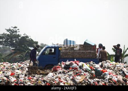 I sequestratori risolvono i rifiuti di plastica riciclabili a discariche illegali sulle rive del fiume CBL, distretto di Bekasi, Bekasi, Giava Occidentale sabato 14 aprile 2018. Con una popolazione di 2,4 milioni di persone, Bekasi come città satellite per Giacarta, si trova ad affrontare gravi problemi legati al trattamento dei rifiuti, che ha raggiunto le 1.700 tonnellate al giorno. In base ai dati dell'Agenzia per l'ambiente di Kota Bekasi, solo 600 tonnellate di rifiuti possono essere trasportate in discarica, mentre le restanti 1.100 tonnellate vengono smaltite in discariche illegali, come nei pressi di insediamenti o lungo il fiume. (Foto di Aditya Irawan/NurPhoto) Foto Stock