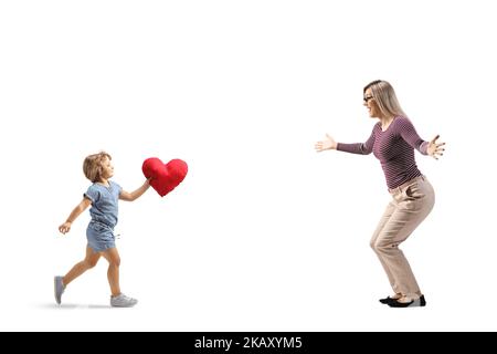 Profilo a tutta lunghezza di una bambina che corre verso la madre con un cuore rosso tra le braccia isolato su sfondo bianco Foto Stock