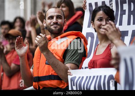 Un uomo che indossa un giubbotto di salvataggio durante una protesta organizzata da attivisti della rete 'noi restiamo umani' che si sono incatenati davanti al ministro italiano delle infrastrutture e dei Trasporti per protestare contro le politiche di immigrazione del governo italiano a Roma, in Italia, il 11 luglio 2018. (Foto di Michele Spatari/NurPhoto) Foto Stock