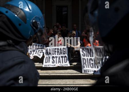 Gli attivisti della rete 'noi restiamo umani' tengono striscioni che leggono 'sinking Rights' mentre vengono incatenati davanti al ministro italiano delle infrastrutture e dei Trasporti per protestare contro le politiche di immigrazione del governo italiano a Roma, in Italia, il 11 luglio 2018. (Foto di Michele Spatari/NurPhoto) Foto Stock