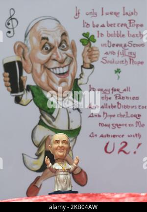 Una piccola testa di Papa Francis Bobble davanti ad una caricatura acquerello che presenta Papa Francis che alloggia una pinta di Guinness e shamrock, realizzata da un artista irlandese Ray Sherlock, in mostra alla Sala Ban Art Gallery di Dublino. Il proprietario della galleria Frank o'Dea li darà gratuitamente con ogni acquisto effettuato durante la visita del Papa in Irlanda. Papa Francesco visiterà l'Irlanda dal 21 al 26 agosto in quella che sarà la prima visita papale da quando il Papa Giovanni Paolo II arrivò nel 1979. Mercoledì 18 2018 luglio a Dublino, Irlanda. (Foto di Artur Widak/NurPhoto) Foto Stock