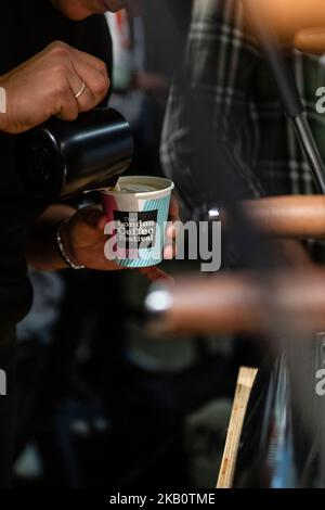 Dettaglio primo piano per il barista che versa il latte in un primo piano di concentrazione del caffè Foto Stock