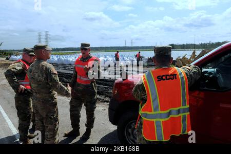 Conway, South Carolina, Stati Uniti - i membri della Guardia Nazionale del South Carolina costruiscono una barriera di sandbag sulla strada statale 501 lungo il lago Busbee a Conway, South Carolina il 17 settembre 2018, dopo il passaggio dell'uragano Firenze. La città di Conway ha fermato i suoi sforzi precedenti per fermare la costruzione della diga di sabbia dopo essere stato assicurato da funzionari statali e della contea il 17 settembre la barriera non avrebbe causato ulteriori inondazioni in Conway. (Foto di Paul Hennessy/NurPhoto) Foto Stock