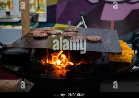 Processo di grigliatura per hamburger su braciere con fiamma calda Foto Stock