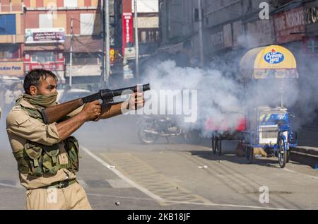 Un poliziotto indiano spara una conchiglia di gas lacrimogeno a Kashmiri sciiti in lutto durante la processione di Muharram il 19 settembre 2018 a Srinagar, la capitale estiva degli indiani amministrato Kashmir, India. Decine di lutto musulmani sciiti sono stati arrestati dalla polizia indiana mentre cercavano di partecipare alla processione durante Muharram, il primo mese del calendario lunare islamico, i musulmani piangono per l'uccisione del nipote del profeta Maometto, Imam Hussain, Che fu assassinato dai suoi rivali politici insieme a 72 compagni nel 680 d.C. in Iraq. I musulmani sciiti piangono flagellandosi con coltelli e spade. India Foto Stock