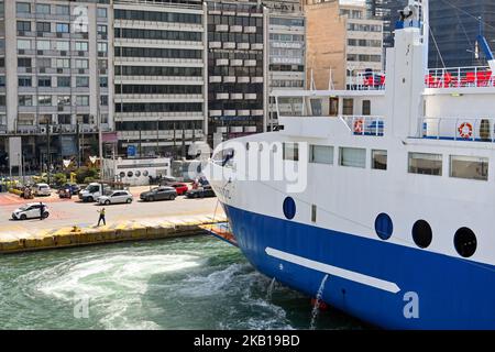 Pireo, Atene, Grecia - 2022 giugno: Grande traghetto guidato in attracco da un operaio nel porto del Pireo. Foto Stock