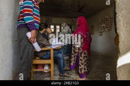 Le donne musulmane di Kashmiri iscrivono i loro nomi prima di votare all'interno di un seggio , durante la seconda fase dei sondaggi municipali, il 10 ottobre 2018 a Srinagar, la capitale estiva degli indiani amministrato Kashmir, India. La scarsa affluenza alle urne ha segnato la seconda fase delle elezioni comunali in Kashmir, in un periodo di parziale chiusura e di forte dispiegamento delle forze governative in tutta la regione. I gruppi pro-indipendenza hanno rifiutato i sondaggi come farsa e hanno chiesto un boicottaggio, mentre anche i principali partiti pro-India come la Conferenza Nazionale e il Partito democratico popolare (PDP) sono rimasti lontani dalle elezioni Foto Stock