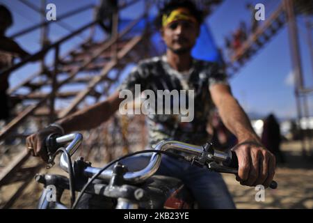 Una moto stuntman posa per le foto al di fuori del pozzo della morte durante una fiera a Kathmandu Domenica, 14 ottobre 2018. (Foto di Narayan Maharjan/NurPhoto) Foto Stock