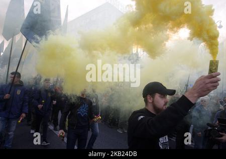 Gli attivisti di estrema destra ucraini assistono il 14 ottobre a una marcia per il 76th° anniversario della costituzione dell'Esercito Insurgente ucraino (UPA) nel centro di Kiev, in Ucraina, 2018.decine di migliaia di attivisti di estrema destra e veterani del conflitto tra le forze governative e i separatisti sostenuti dalla Russia nella parte orientale dell'Ucraina hanno camminato per il centro di Kiev, sventolando bandiere rosse e nere, simbolo del movimento nazionalista, E bandiere ucraine blu e gialle. Gli attivisti si sono riuniti nella capitale Ucraina per celebrare il 76th ° anniversario della costituzione dell'esercito ucraino Insurgent ( Foto Stock