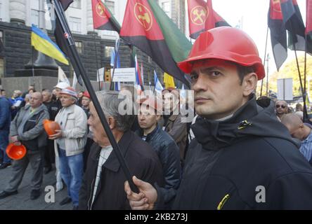 Gli ucraini detengono cartelli e bandiere durante un raduno organizzato dalla Federazione dei sindacati ucraini, di fronte al Gabinetto dei Ministri, a Kiev, in Ucraina, il 17 ottobre 2018. Migliaia di ucraini hanno partecipato a un raduno dedicato alla Giornata internazionale per l'eliminazione della povertà, chiedendo un aumento del salario minimo, a bassi tassi di alloggi e di utilità, e assicurando lo sviluppo della produzione interna per creare posti di lavoro con un salario adeguato. (Foto di NurPhoto) Foto Stock