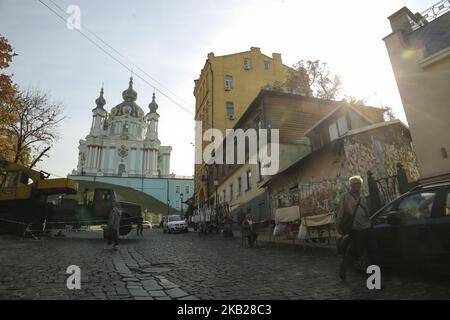 Venditore di strada è visto come la gente cammina oltre la Chiesa di Sant'Andrea a Adriyivskiy discesa a Kyiv, Ucraina, 19 ottobre 2018. il parlamento ucraino il 16 ottobre 2018 ha votato per consegnare la Chiesa di Sant'Andrea a Kiev al Patriarcato ecumenico di Istanbul dopo aver accettato di riconoscere l'indipendenza della Chiesa ortodossa Ucraina dal Patriarcato di Mosca. (Foto di Sergii Kharchenko/NurPhoto) Foto Stock