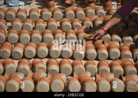 Una donna nepalese che asciuga pentole a Piazza della ceramica a Bhaktapur, Nepal il Mercoledì, 24 ottobre 2018, dove su piccola scala tradizionale ceramica industria di fabbricazione sono trovati. Bhaktapur è un'antica città della valle di Kathmandu ed è dichiarata patrimonio dell'umanità dall'UNESCO per la sua ricca cultura, i templi e le opere d'arte in legno, metallo e pietra. (Foto di Narayan Maharjan/NurPhoto) Foto Stock