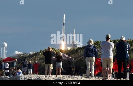 La gente guarda da Playalinda Beach a Canaveral National Seashore come un razzo SpaceX Falcon 9 lancia con successo il satellite di comunicazione es'Hail-2 per il paese del Qatar il 15 novembre 2018 dal pad 39A al Kennedy Space Center in Florida, Stati Uniti. (Foto di Paul Hennessy/NurPhoto) Foto Stock