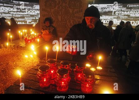 Un uomo ucraino accende una candela in memoria delle vittime della Grande carestia ( l'Holodomor) in Ucraina del 1932-1933, in un monumento alle vittime dell'Holodomor a Kiev, Ucraina, 24 novembre 2018. L'Ucraina ha segnato 85 anni dalla Grande carestia dell'era di Stalin (l'Holodomor). La carestia del 1932-33 si è svolta con la diminuzione dei raccolti e la polizia del dittatore sovietico Josef Stalin ha applicato la politica brutale di collettivizzare l'agricoltura imponendo cereali e altri prodotti alimentari. Il risultato è stato la morte di più di cinque milioni di persone e che molti considerano un genocidio. (Foto di NurPhoto) Foto Stock