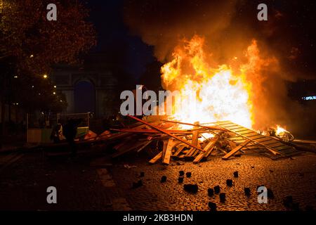 Parigi, Francia, 24 novembre 2018. I manifestanti hanno creato una barricata durante una protesta dei giubbotti gialli (Gilets jaunes) contro l'aumento dei prezzi del petrolio e dei costi della vita nei pressi dell'Arco di Trionfo sul viale foch. Le forze di sicurezza di Parigi hanno sparato gas lacrimogeno e cannone ad acqua per disperdere i manifestanti. (Foto di Emeric Fohlen/NurPhoto) Foto Stock