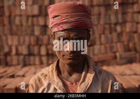 Un lavoro del Bangladesh si propone per una fotografia in un campo di mattoni a Dhaka, Bangladesh, il 28 novembre 2018. I lavoratori lavorano nei campi di mattoni fino al crepuscolo con condizioni malsane in quanto il loro stipendio non soddisfa gli standard minimi. (Foto di Rehman Asad/NurPhoto) Foto Stock