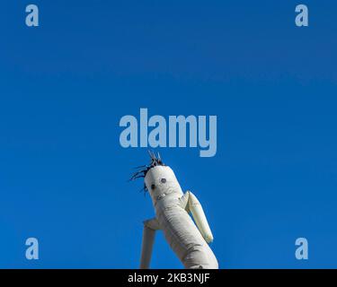 Un tizio grigio del tubo gonfiabile di ondulazione si muove contro un cielo blu chiaro. Foto Stock