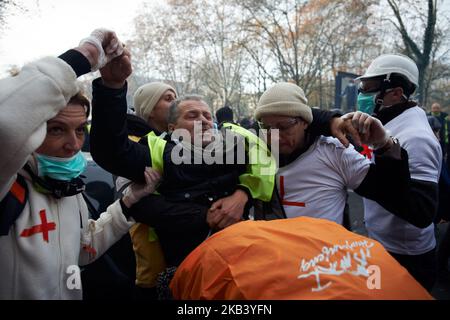 I paramedici Yellow Vests prendono via un uomo ferito da flashball nella gamba. I gilet gialli hanno dimostrato ancora per la 4th volta. Volontari paramedici sono venuti per dare il primo aiuto alle persone ferite e irritati da gas lacrimogeni lanciati dalla polizia tumulto durante la protesta e durante la sommossa. Le proteste dei giubbotti gialli sono iniziate come una protesta contro l'aumento delle tasse sul carburante e ora si oppongono alle politiche di Macron e hanno chiesto le sue dimissioni. Più di 10 000 persone sono scese in strada. A Tolosa, Francia il 8 dicembre 2018. (Foto di Alain Pitton/NurPhoto) Foto Stock