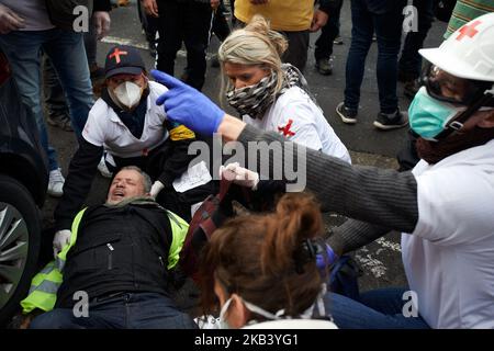 I paramedici Yellow Vests danno il primo aiuto ad un uomo ferito da flashball nella gamba. I gilet gialli hanno dimostrato ancora per la 4th volta. Volontari paramedici sono venuti per dare il primo aiuto alle persone ferite e irritati da gas lacrimogeni lanciati dalla polizia tumulto durante la protesta e durante la sommossa. Le proteste dei giubbotti gialli sono iniziate come una protesta contro l'aumento delle tasse sul carburante e ora si oppongono alle politiche di Macron e hanno chiesto le sue dimissioni. Più di 10 000 persone sono scese in strada. A Tolosa, Francia il 8 dicembre 2018. (Foto di Alain Pitton/NurPhoto) Foto Stock