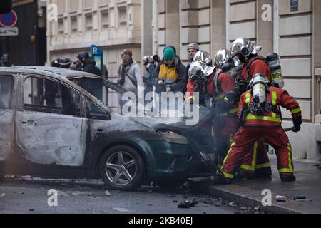 I vigili del fuoco hanno visto spegnere un'auto in fiamme. Scontri e vandalismo che hanno provocato migliaia di arresti, di cui più di 1.700 sabato 8 dicembre 2018, scaturiscono dalle proteste dei “giubbotti gialli”, un movimento anti-governativo. Blocchi stradali e molte azioni tra i dimostranti e la polizia si sono verificati intorno all'Arco di Trionfo e agli Champs Elysees con negozi rotti, auto bruciate o danneggiate, blocchi stradali con fuoco, violenza e molto fumo di gas lacrimogeno dalla polizia. (Foto di Nicolas Economou/NurPhoto) Foto Stock