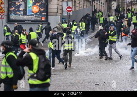 Manifestanti visti nel fumo di gas lacrimogeno a Champ Elysees vicino all'Arco di Trionfo durante la dimostrazione del gilet giallo. Scontri e vandalismo che hanno provocato migliaia di arresti, di cui più di 1.700 sabato 8 dicembre 2018, scaturiscono dalle proteste dei “giubbotti gialli”, un movimento anti-governativo. Blocchi stradali e molte azioni tra i dimostranti e la polizia si sono verificati intorno all'Arco di Trionfo e agli Champs Elysees con negozi rotti, auto bruciate o danneggiate, blocchi stradali con fuoco, violenza e molto fumo di gas lacrimogeno dalla polizia. (Foto di Nicolas Economou/NurPhoto) Foto Stock