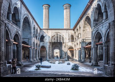 Il 9 dicembre 2018, i turisti scattano foto della tarda architettura Seljuk del Cifte Minarelli Medrese, noto anche come il Twin Minareto Madrasa, nel centro storico di Erzurum, una destinazione per gli sport invernali nell'Anatolia orientale della Turchia. (Foto di Diego Cupolo/NurPhoto) Foto Stock