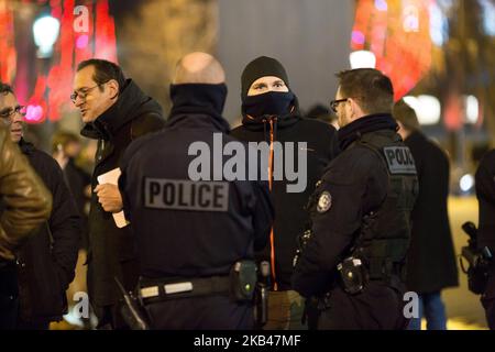 Un poliziotto francese parla con i colleghi in servizio, mentre egli dimostra sulla via degli Champs Elysées il 20 dicembre 2018 a Parigi al appello di MPC (Mouvement of Angry poliziotti) per il miglioramento delle loro condizioni di lavoro. Dopo più di un mese di monitoraggio delle proteste dei gilet gialli, i poliziotti francesi che si sentivano già sovraccarichi di lavoro, dicono di averne avuto abbastanza. Dopo diverse ore di negoziati tra il ministro francese dell'interno Christophe Castaner e i tre principali sindacati di polizia francesi, è stato finalmente raggiunto un accordo sugli stipendi degli ufficiali. Il governo francese ha accettato Foto Stock