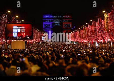 La gente si riunisce vicino all'Arco di Trionfo illuminato sugli Champs-Elysees per le celebrazioni di Capodanno nella capitale francese Parigi il 31 dicembre 2018. Uno spettacolo di fuochi d'artificio e uno spettacolo di suoni e luci con il tema 'Fraternity' e' allestito a Passi pure sugli Champs-Elysees nonostante i piani per ulteriori proteste anti-governative 'gileta' nel famoso viale. (Foto di Sameer al-Doumy/NurPhoto) Foto Stock