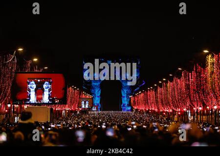 La gente si riunisce vicino all'Arco di Trionfo illuminato sugli Champs-Elysees per le celebrazioni di Capodanno nella capitale francese Parigi il 31 dicembre 2018. Uno spettacolo di fuochi d'artificio e uno spettacolo di suoni e luci con il tema 'Fraternity' e' allestito a Passi pure sugli Champs-Elysees nonostante i piani per ulteriori proteste anti-governative 'gileta' nel famoso viale. (Foto di Sameer al-Doumy/NurPhoto) Foto Stock