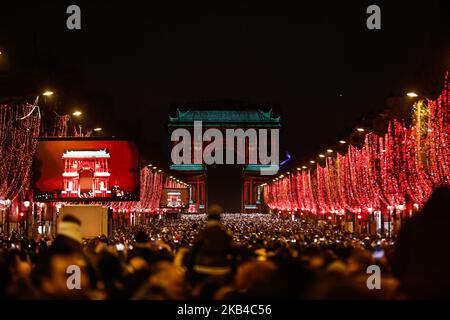 La gente si riunisce vicino all'Arco di Trionfo illuminato sugli Champs-Elysees per le celebrazioni di Capodanno nella capitale francese Parigi il 31 dicembre 2018. Uno spettacolo di fuochi d'artificio e uno spettacolo di suoni e luci con il tema 'Fraternity' e' allestito a Passi pure sugli Champs-Elysees nonostante i piani per ulteriori proteste anti-governative 'gileta' nel famoso viale. (Foto di Sameer al-Doumy/NurPhoto) Foto Stock